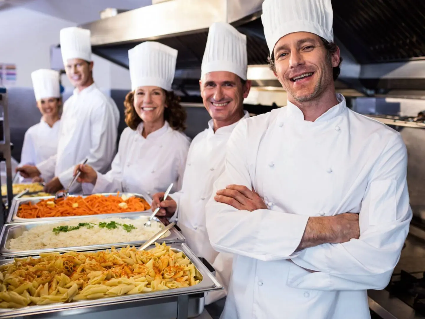 Chefs smiling with trays of food.