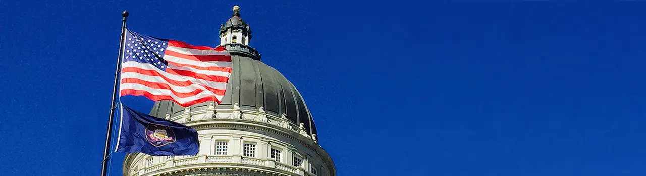 Capitol dome with American and Utah flags.