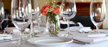 Elegant dining table setup with flowers and wine glasses.