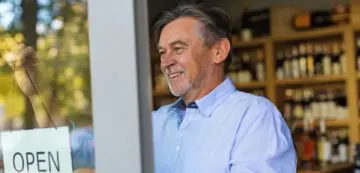 Smiling man working on a computer in a cozy environment.