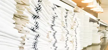 Stacks of neatly folded white towels with black stripes.
